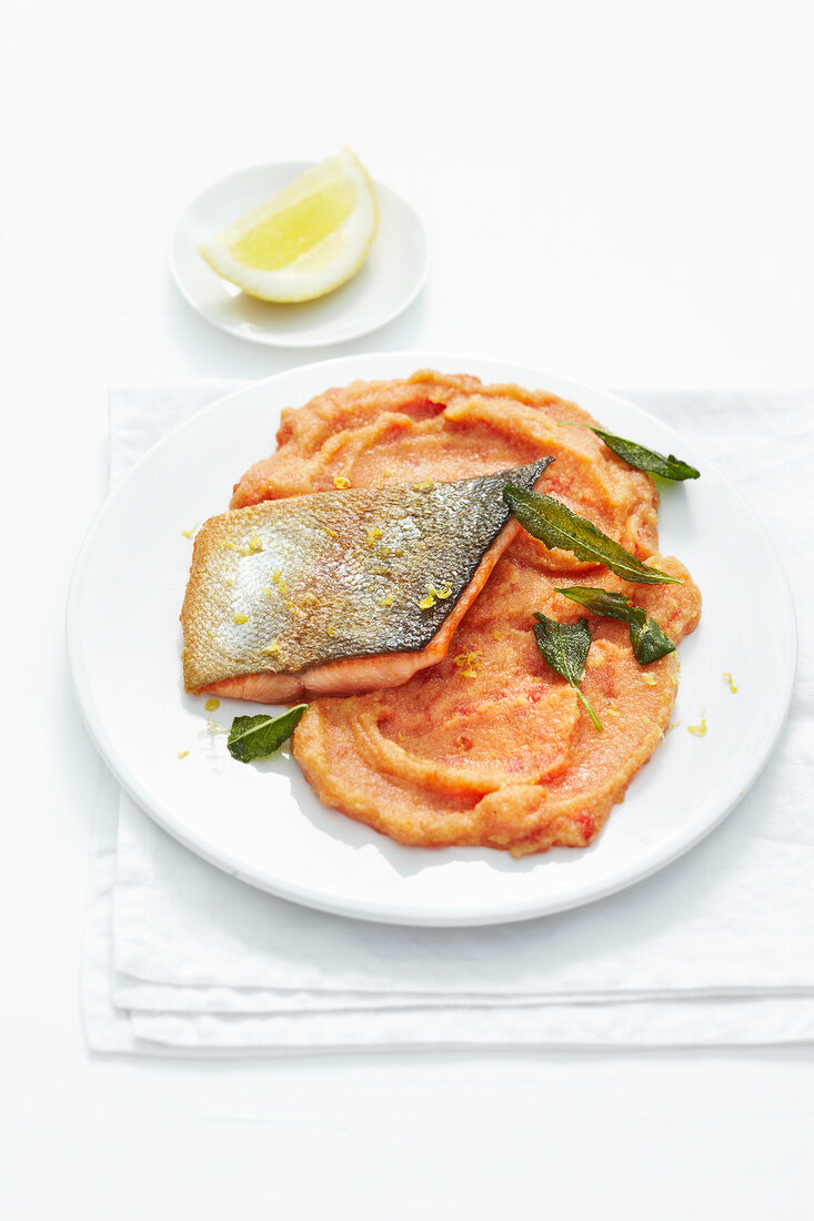 Salmon trout with tomato polenta on plate