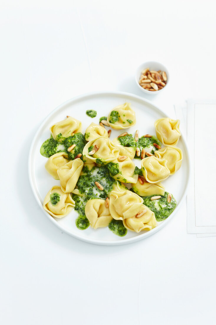 Tortellini with spinach and cheese sauce in serving dish
