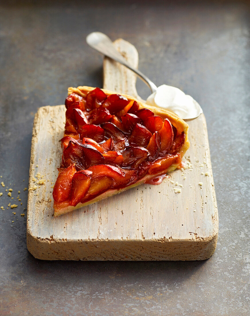 Slice of plum tart on chopping board, Bavaria, Germany