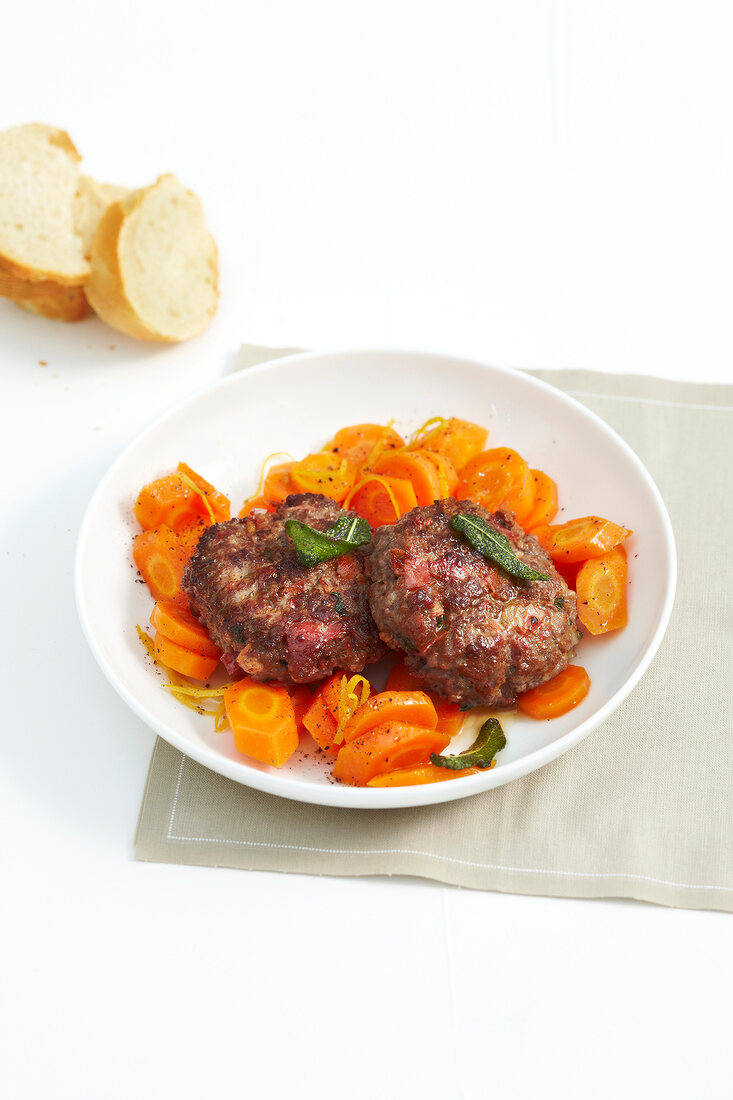 Sage meatballs with carrot slices on plate