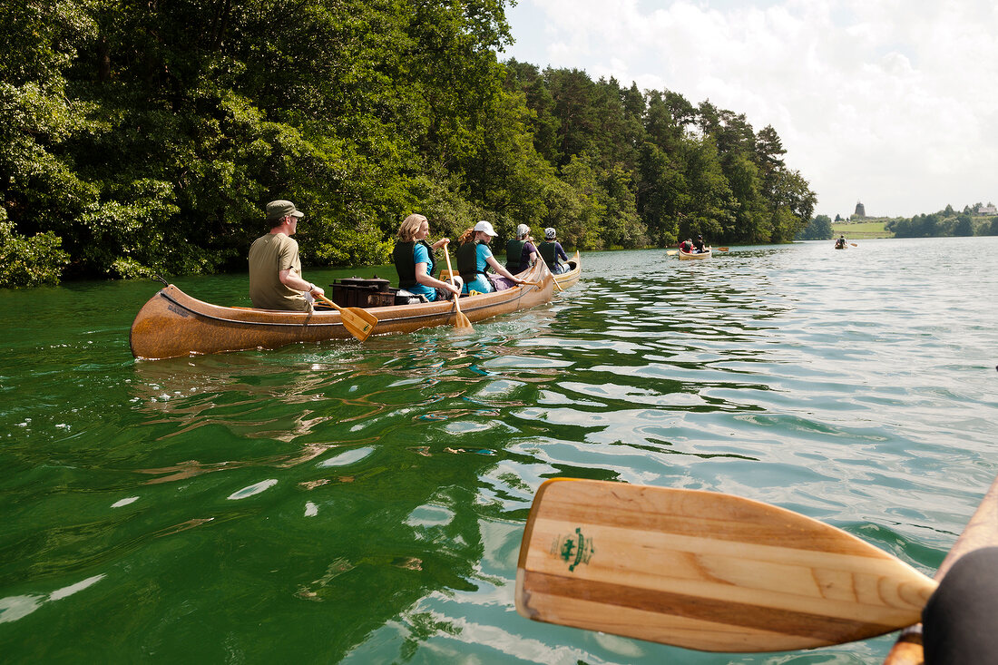 People on canoe trip in Uckermark Lakes Nature Park, Brandenburg, Germany