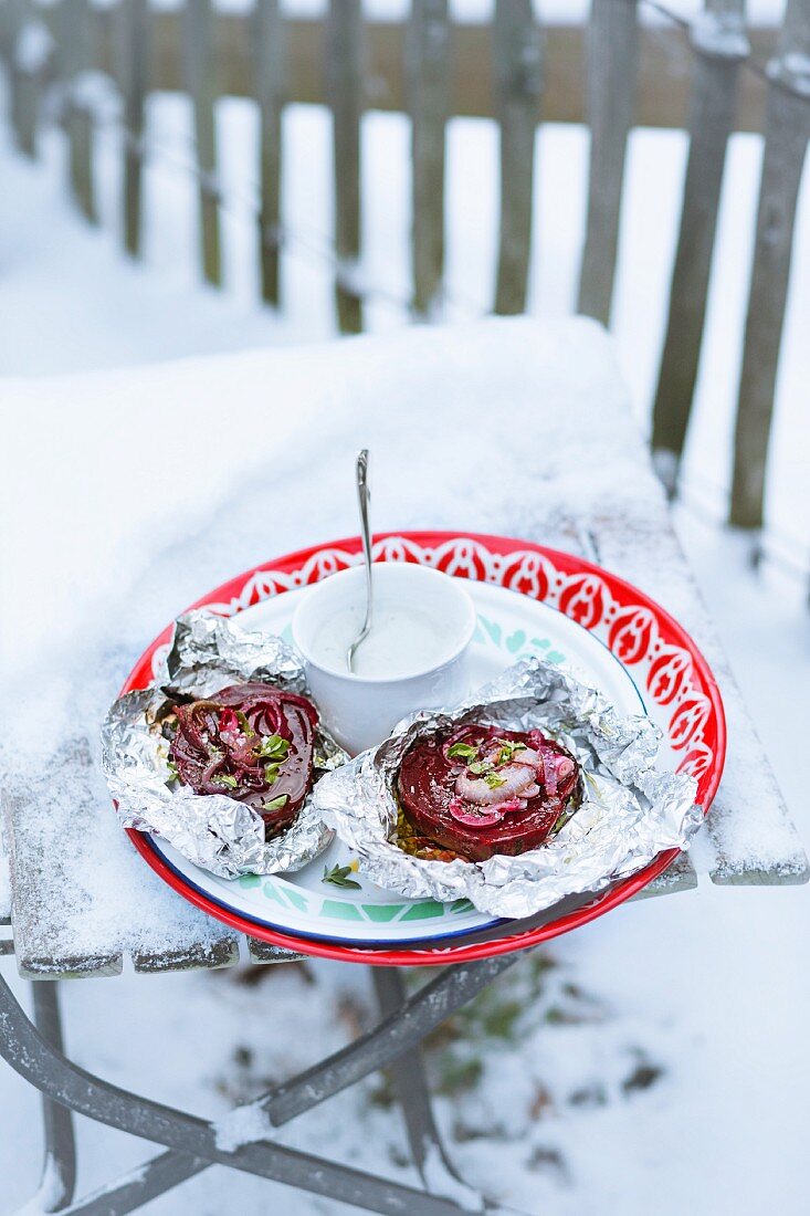 Beetroot with wasabi sour cream on a piece of aluminium foil in the snow