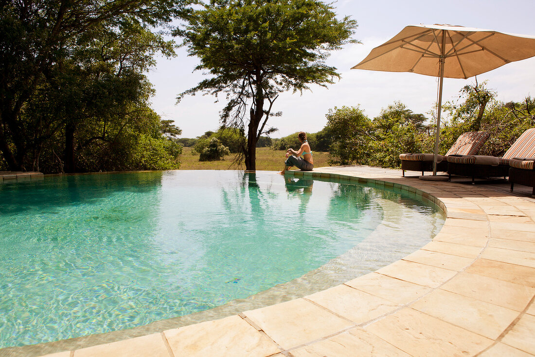 Woman sitting at pool in Forest Lodge, South Africa