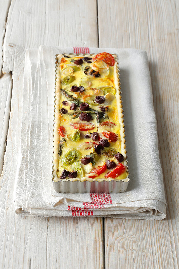 Leek and tomato quiche in baking dish