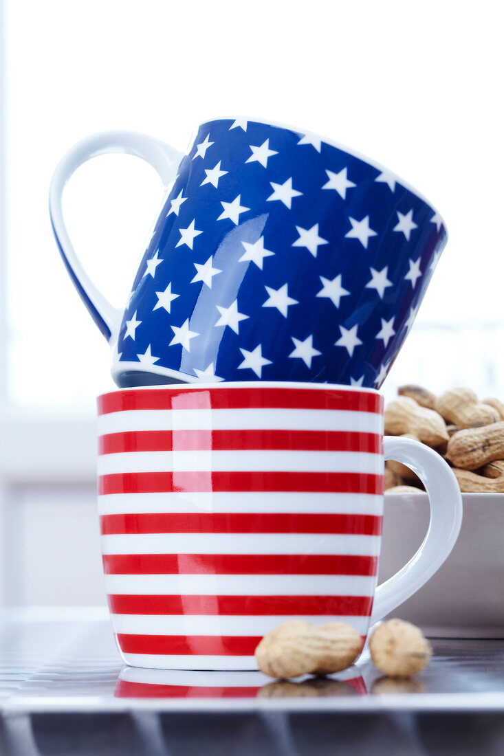 Stars and striped mugs with peanuts by side