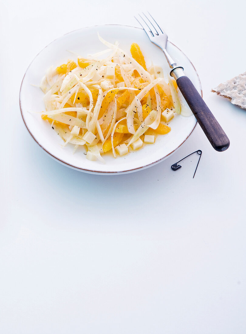 Bowl of fennel salad with oranges on white surface