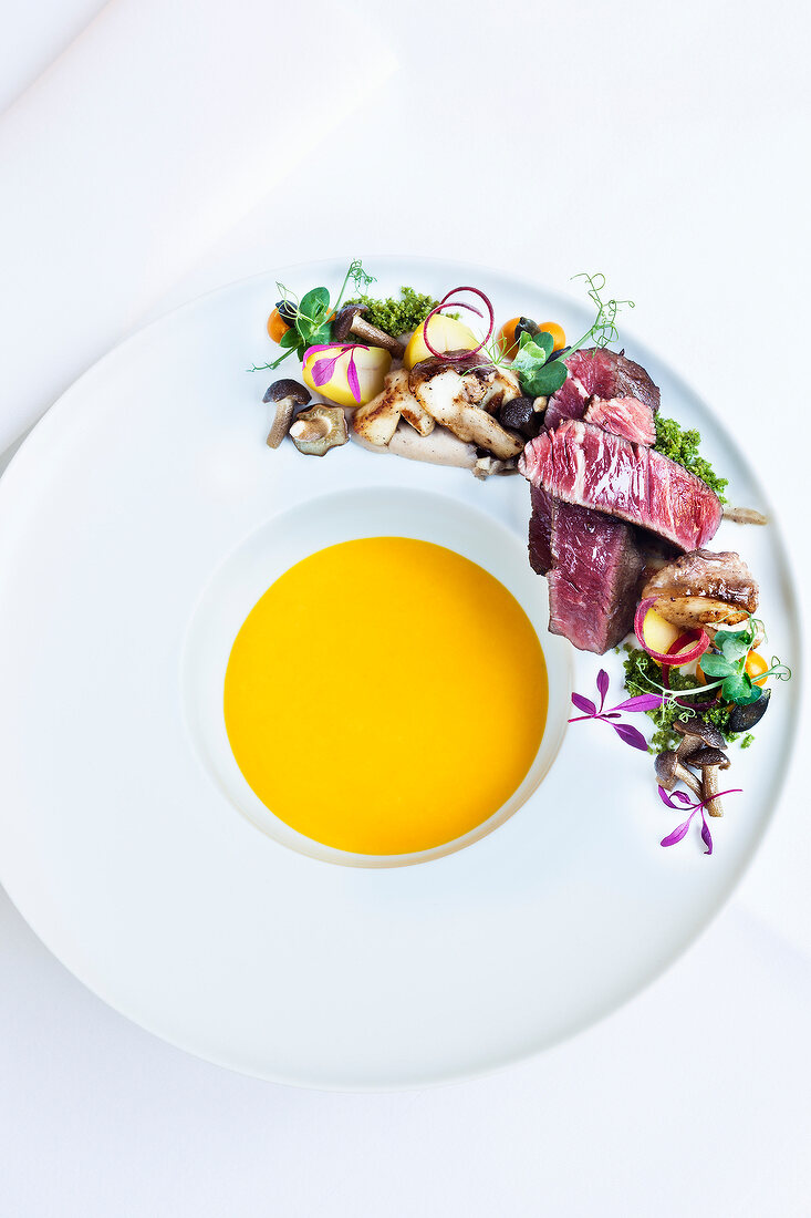 Ebisu-pumpkin soup with beef tenderloin, mushrooms on serving plate