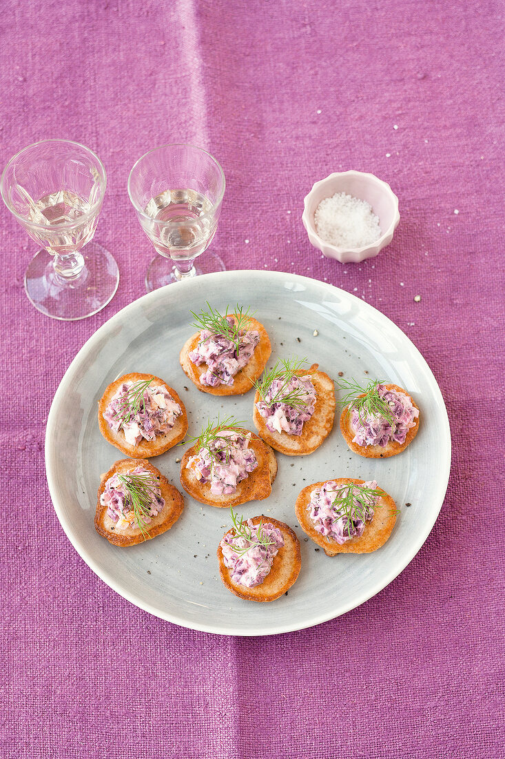 Blinis with egg salad on plate over pink table cloth