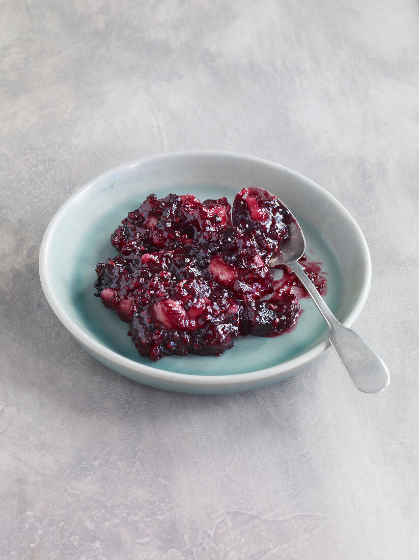 Fruit jam with marzipan and berry on plate