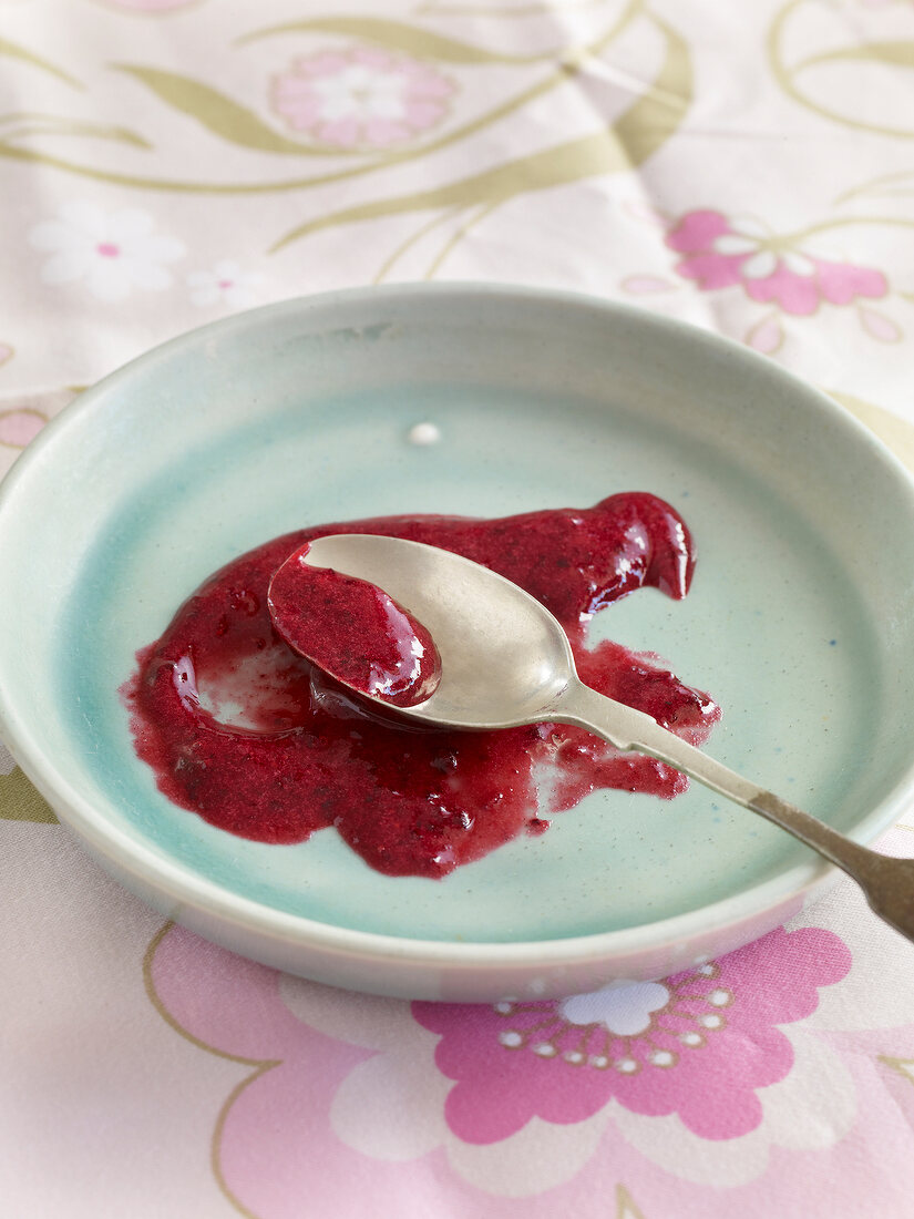 Berry jam with spoon on plate