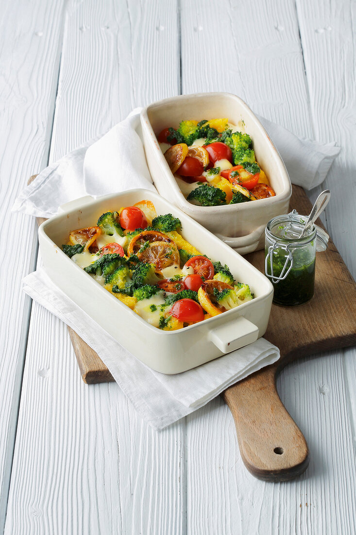 Two bowls of polenta gratin on wooden serving board