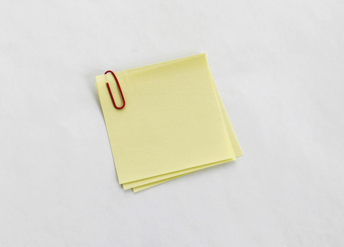 Yellow sticky notes with paper clip on white background