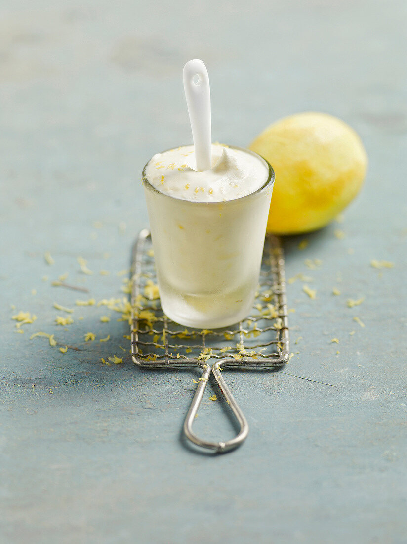 Close-up of lemon ice pop with lemon zest in glass