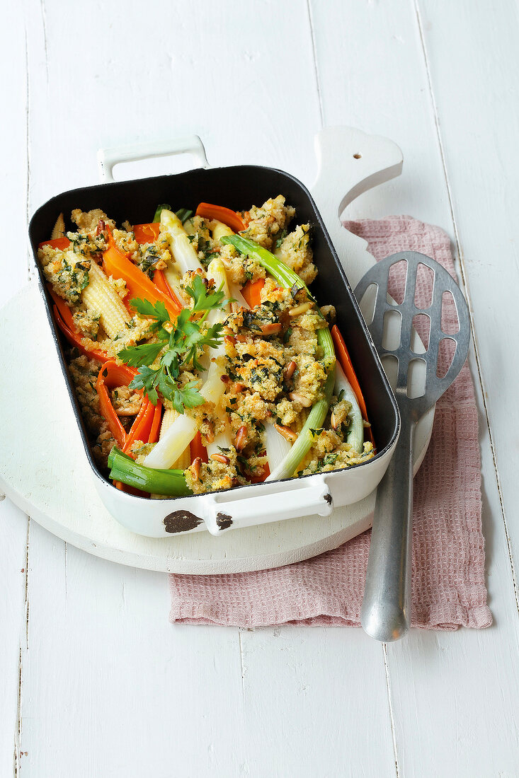 Spring vegetables with bread crust in serving dish