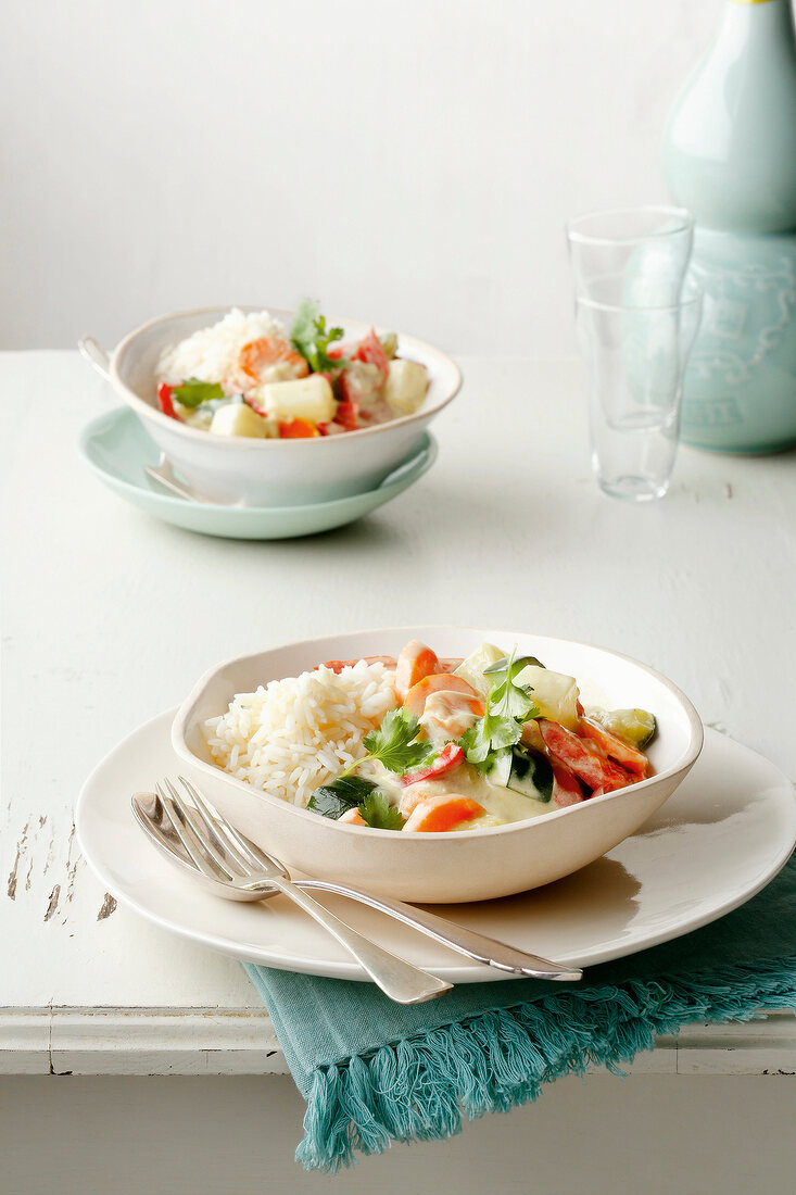 Green vegetable curry and rice in bowls