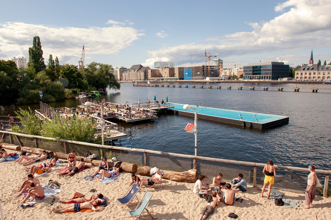 View of people relaxing on sand and bathing ship on river Spree in Berlin, Germany