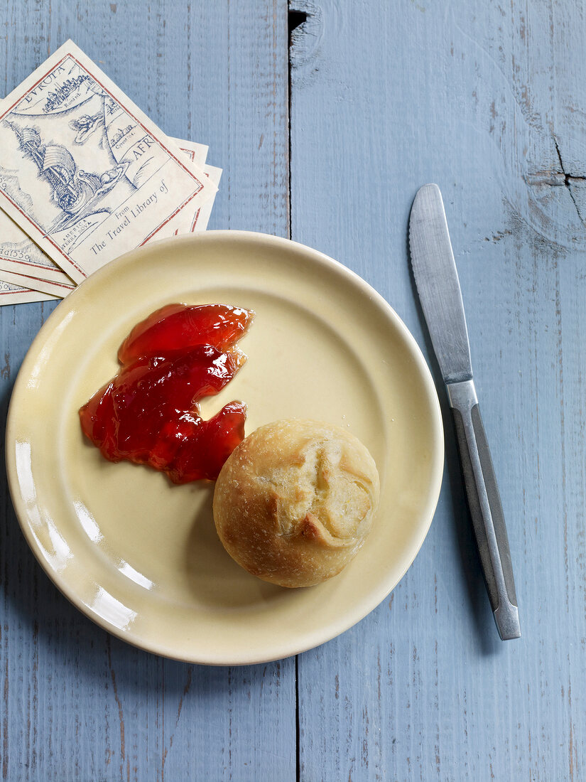 Current jelly and rolls on plate with knife