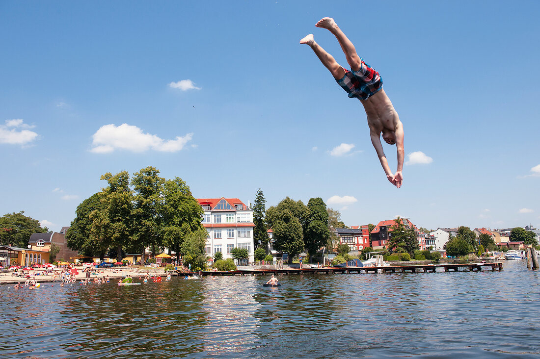 Man diving in Muggelsee lake in Berlin, Germany