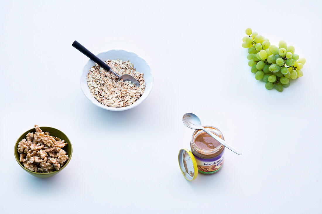 Grapes, cereals and nuts on white background