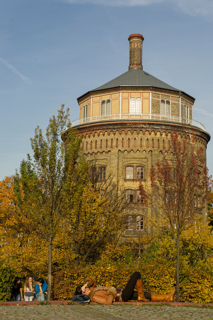 People relaxing in park with building in background at Prenzlauer Berg, Berlin, Germany