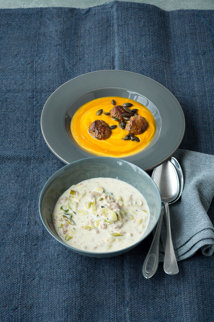 Pumpkin and sweet potato soup with meatballs and cheese and leek soup in bowls