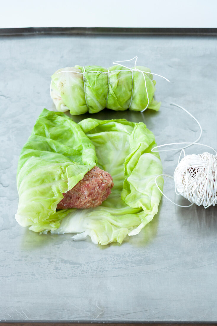 Minced meat being wrapped in cabbage leaf, step 2