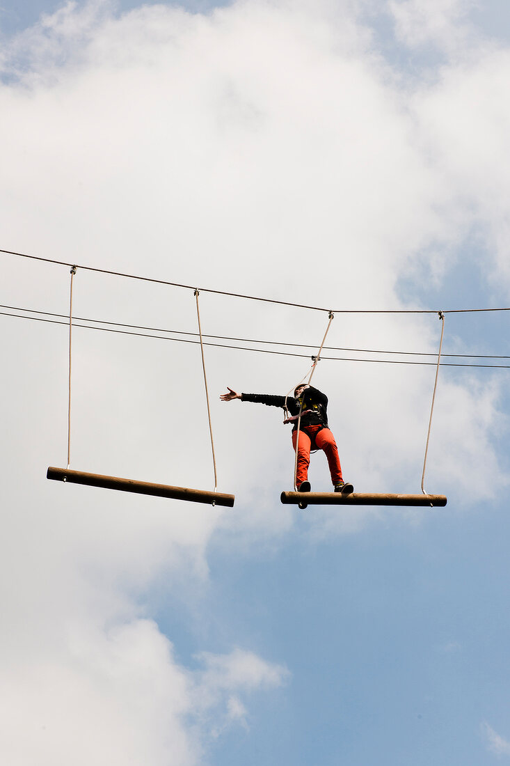 Man taking high ropes course in amusement park at Dankern Leisure Centre Castle, Germany