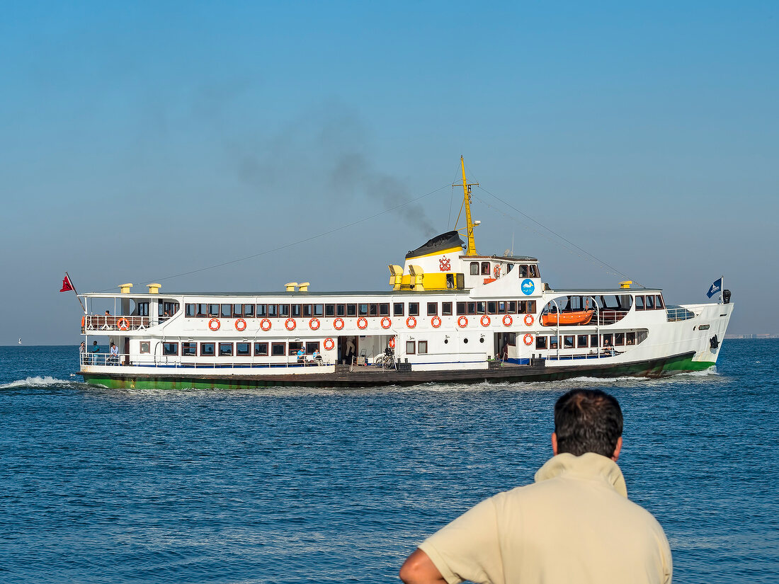 Man at promenade looking at ferry in sea, Izmir, Aegean Region, Turkey