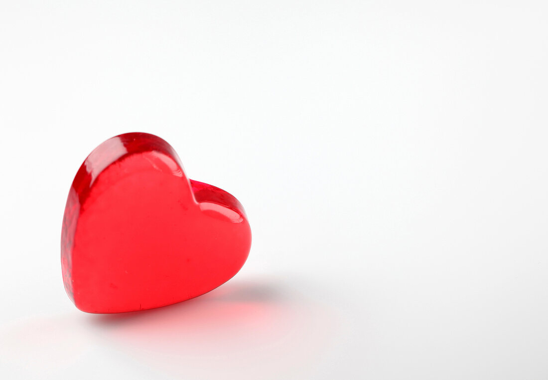 Red glass heart on white background