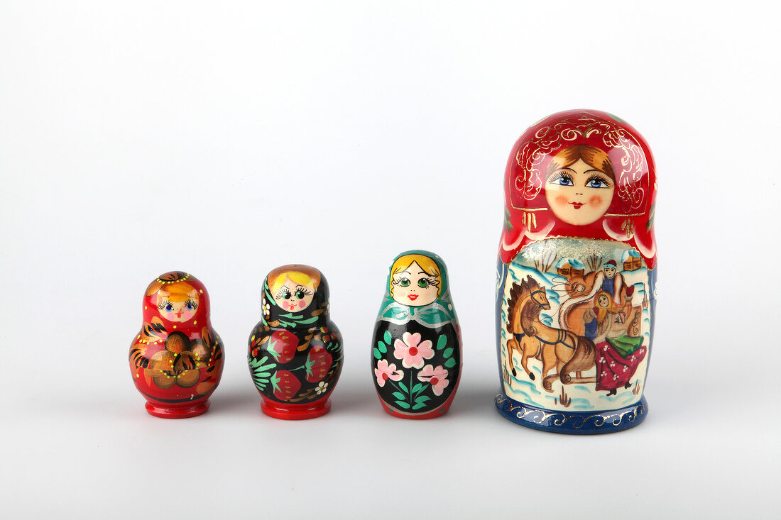 Five Russian dolls of various size on white background