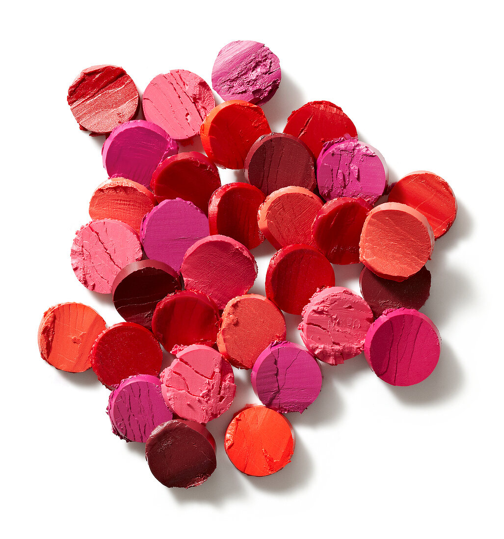 Different shades of disc manner lipsticks on white background