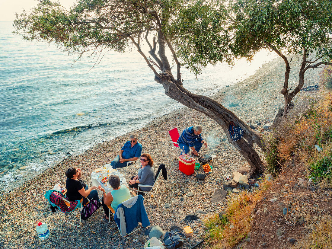 People sitting on the coats of Kucukkuyu in Mediterranean, Aegean, Turkey