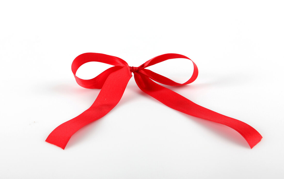 Close-up of red satin bow on white background