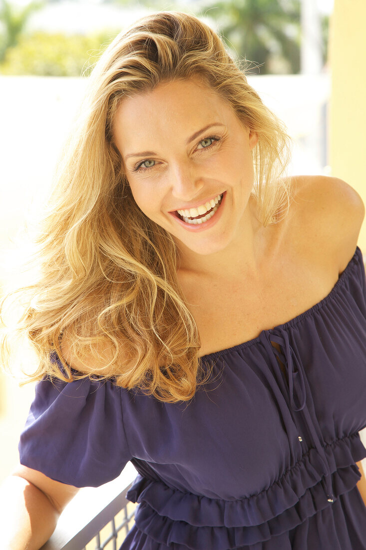 Portrait of beautiful woman wearing purple blouse, laughing