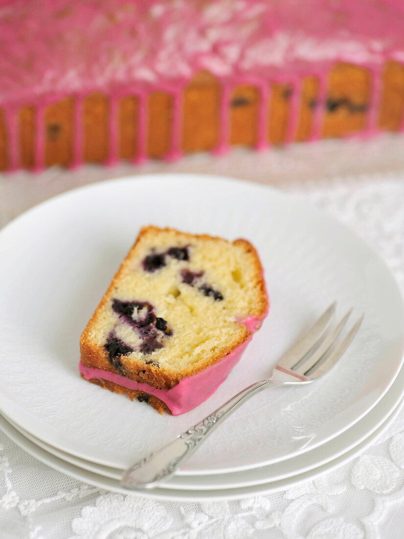 Slice of blueberry cake with blueberry on plate