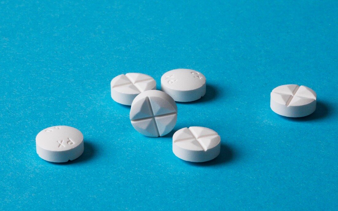 Close-up of white round tablet on blue background