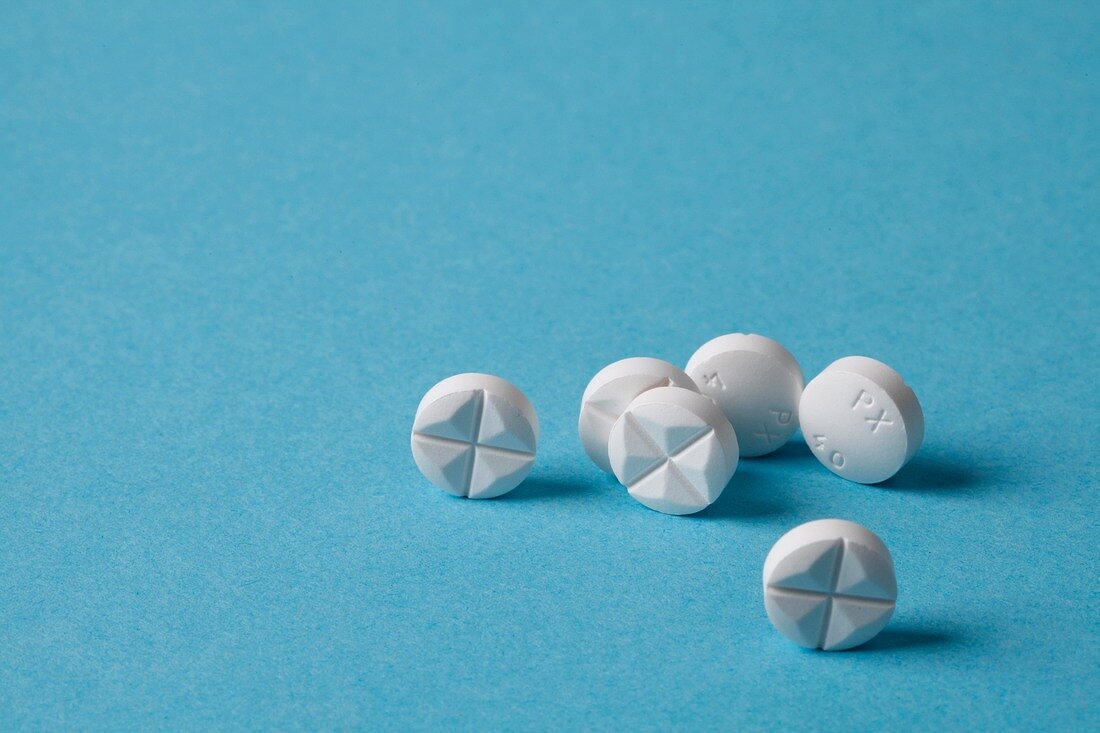 Close-up of white tablets on blue background