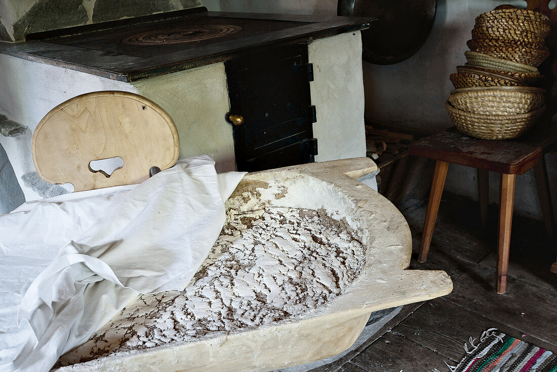 Brotlaib in Gärkörbchen aus Holz, zugedeckt, Ofen