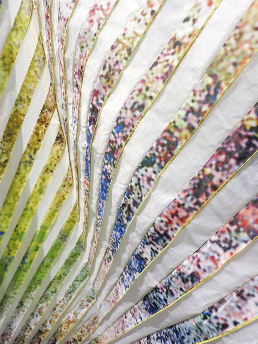 Close-up of pleated fabric from fine colourful stripes