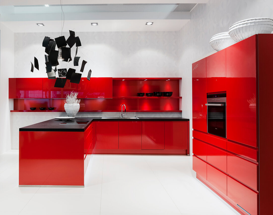 View of red lacquered kitchen with black work top
