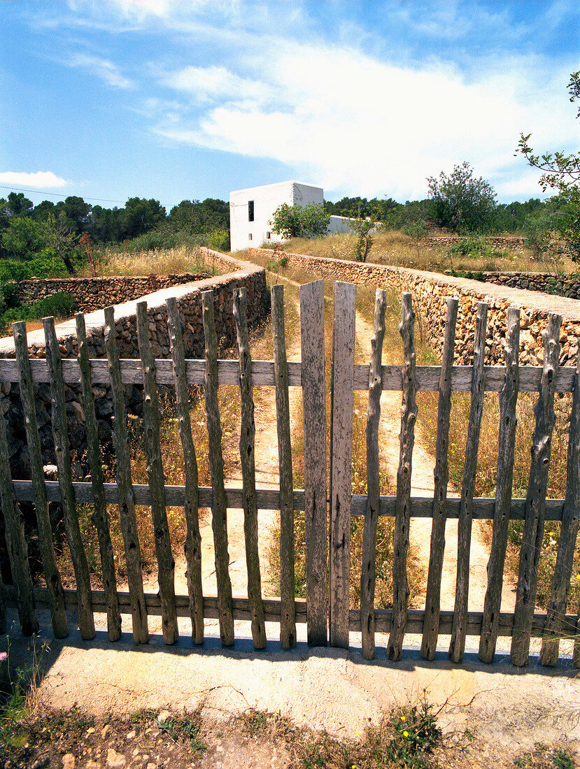 White house with field walls and old gate in Ibiza island, Spain