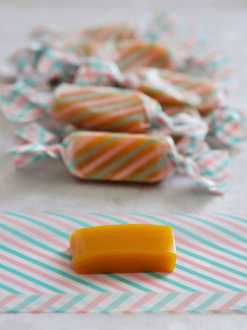 Caramel candies with coconut and passion fruit on wrapping paper