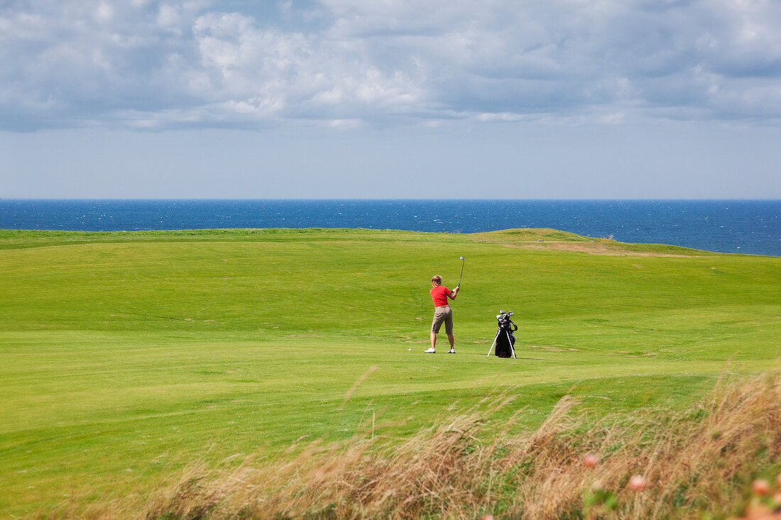 Man playing golf in Golf Course, Cape Breton island, Nova Scotia, Canada