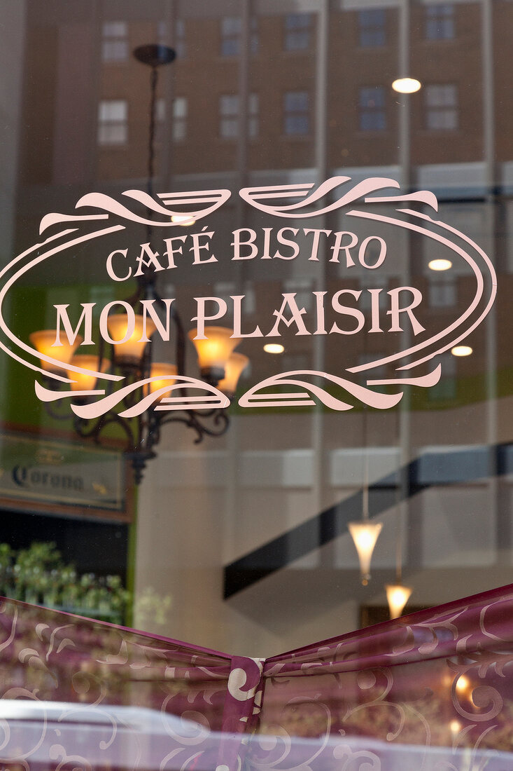 Close-up of cafe Bistro Mon Plaisir sign on glass window at Montreal, Canada