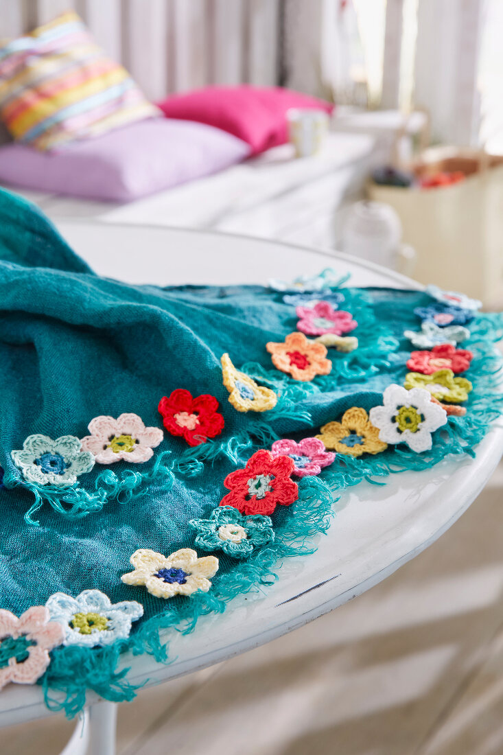 Turquoise plaid blanket with colourful crocheted flowers