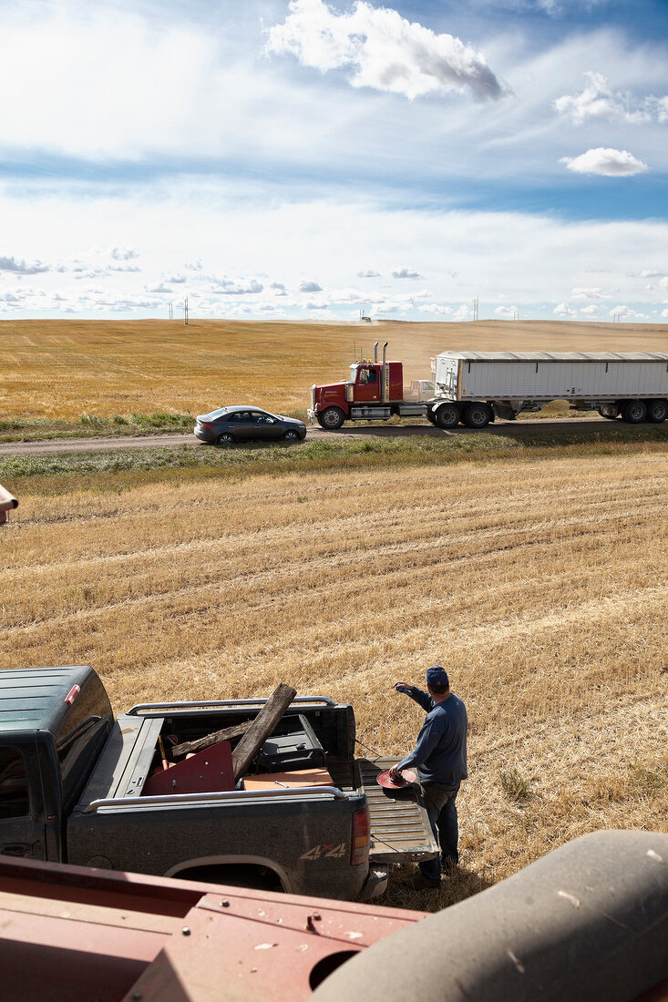 View of trucks on cornfield for agriculture, Saskatchewan, Canada