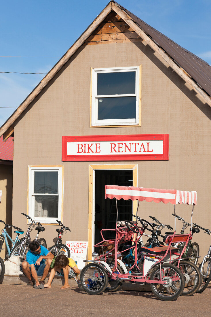 People sitting at bike rental shop in Prince Edward Island National Park, Canada
