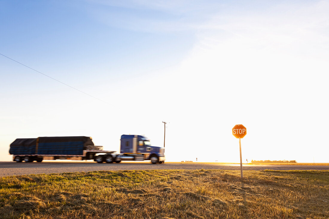 View of truck and stop sign board on highway, Saskatchewan, Canada
