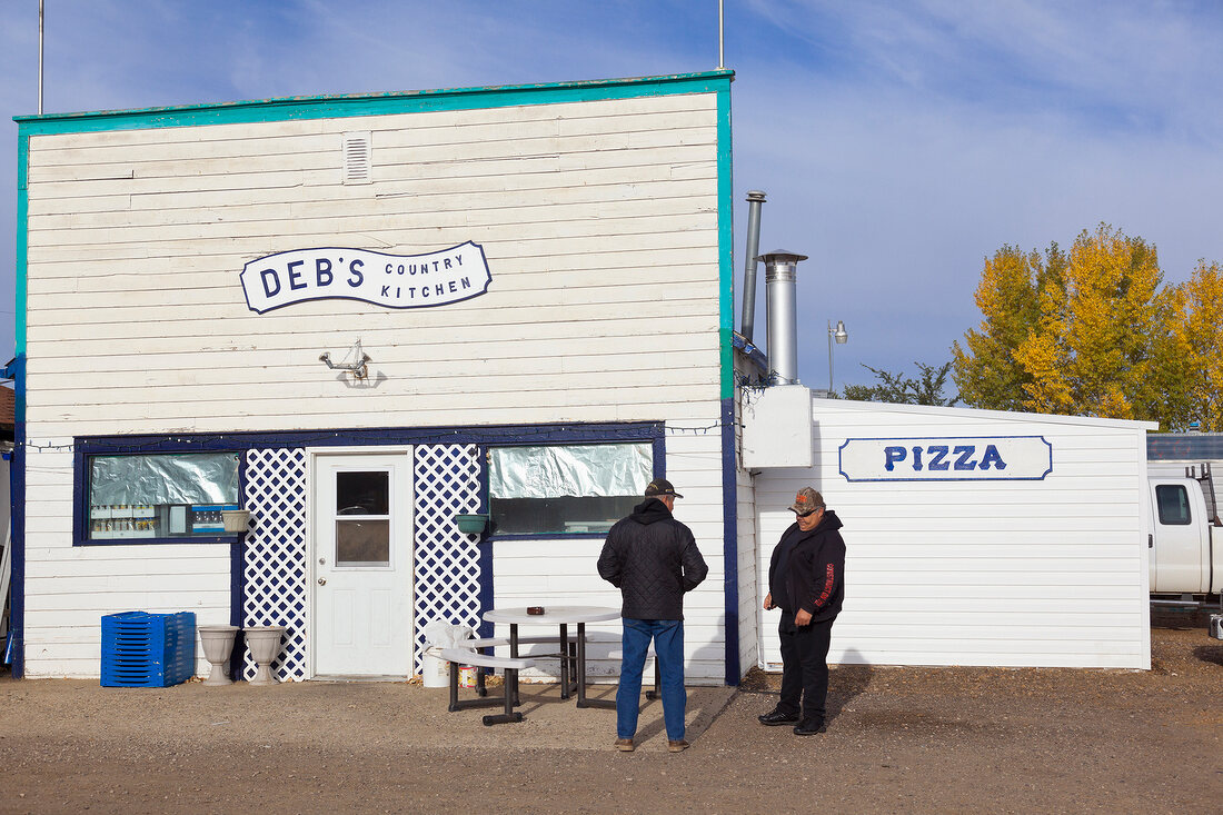 Two men standing in front of Deb's Country restaurant in Coronach, Saskatchewan, Canada