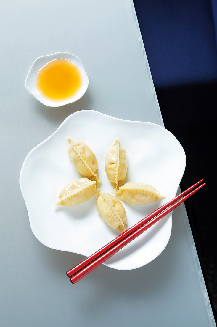 Ravioli with dip and chopsticks on plate
